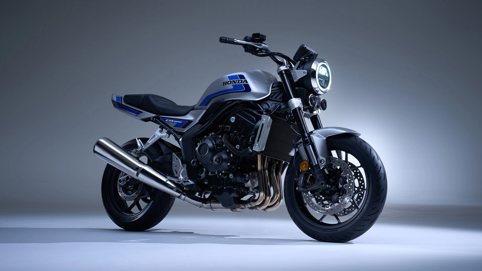 Front three-quarter view of the Honda CB1000F naked bike with round LED headlight and muscular fuel tank.